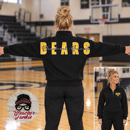 A woman stands on a basketball court with her arms outstretched, wearing a black sweatshirt and matching sweatpants. The back of the sweatshirt has large yellow 'BEARS' lettering, and a smaller inset shows the front of the sweatshirt with a small yellow 'BEARS' logo.